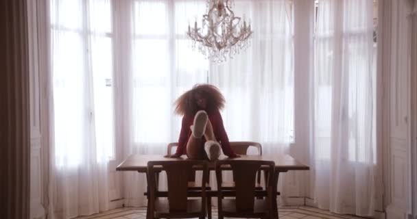Femme noire dansant sur la table de la salle à manger secouant ses jambes — Video