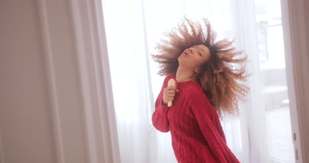 Schwarze Frau singt in Haarbürste, tanzt und schüttelt die Haare — Stockvideo