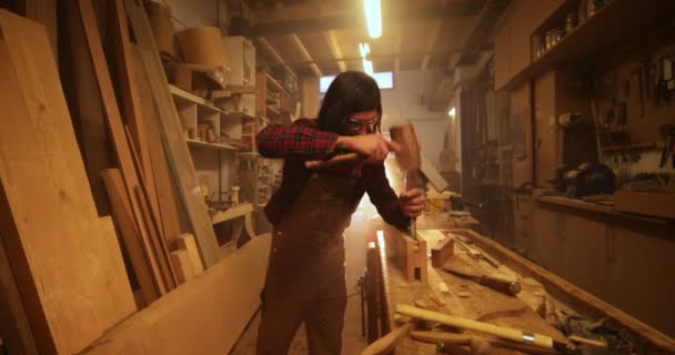 Hombre en taller tallando barra de madera con martillo y cincel — Vídeo de stock