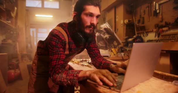 Homme en atelier de menuiserie à l'aide d'un ordinateur portable — Video