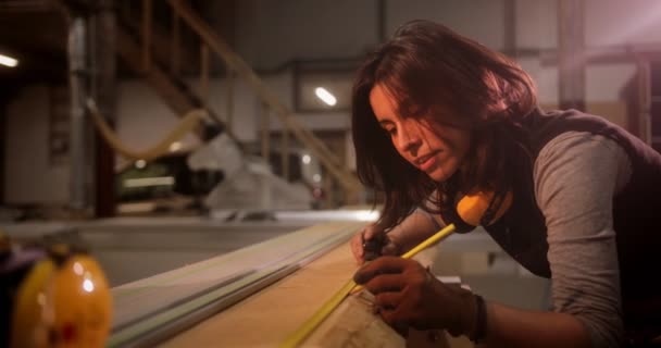 Žena měření dřevěné desky v truhlářské dílně — Stock video