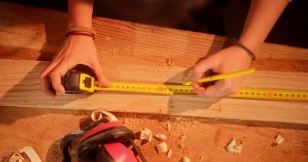 Gros plan des mains de menuisiers mesurant la planche en bois — Video