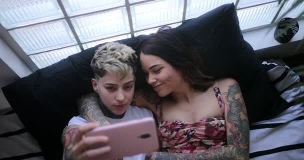 Pareja lesbiana tomando selfie en la cama novia besando a su pareja — Vídeos de Stock