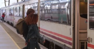 Tren istasyonunda çok ırklı bir çift trene biniyor.