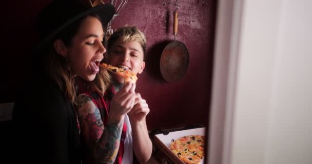 Lésbicas casal tendo take-away pizza alimentando uns aos outros — Vídeo de Stock