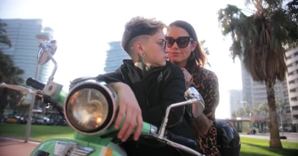 Lesbičky pár sedí spolu na motorce v ulicích města — Stock video