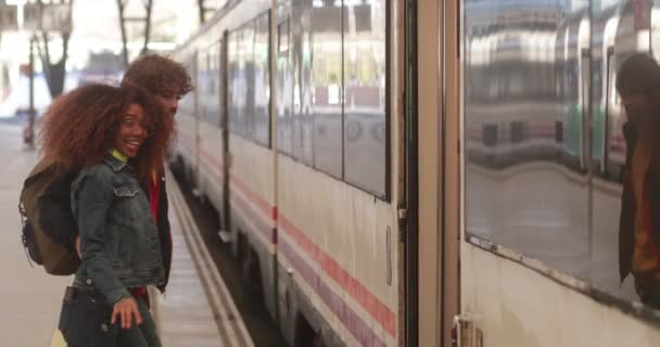 Treno di imbarco multietnico coppia sul binario alla stazione ferroviaria — Video Stock