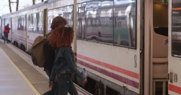 Treno di imbarco multietnico coppia sul binario alla stazione ferroviaria — Video Stock