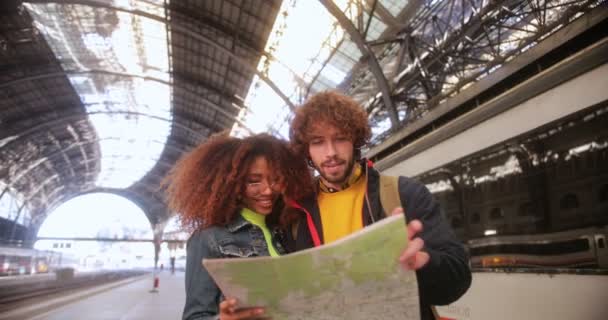 Coppie multietniche controllano la mappa sulla piattaforma ferroviaria alla stazione ferroviaria — Video Stock