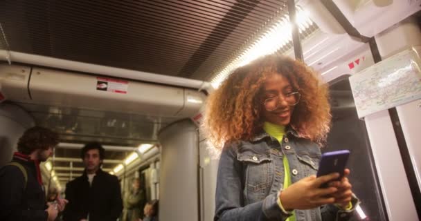 Mladá černošky žena pomocí smartphone při cestování vlakem — Stock video