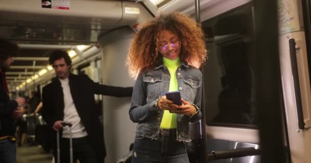 電車に乗りながらスマホを使う若い黒人女性 — ストック動画