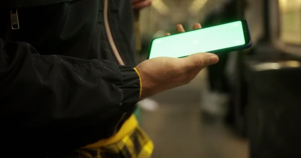 Κοντινό πλάνο άνθρωπος χρησιμοποιώντας smartphone με πράσινη οθόνη στο τρένο — Αρχείο Βίντεο