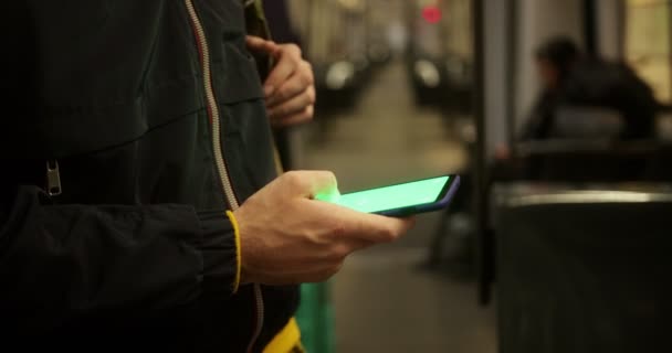 Nahaufnahme eines Mannes mit Smartphone und grünem Bildschirm im Zug — Stockvideo