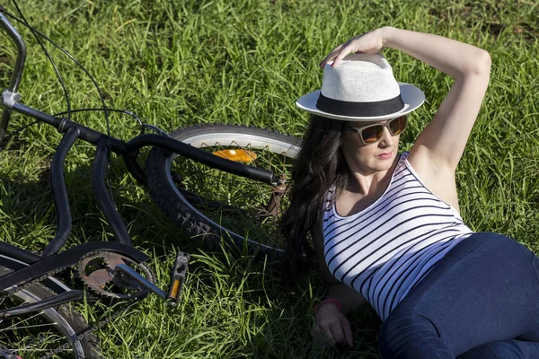 Kobiece turystycznych z roweru, leżąc na trawie — Zdjęcie stockowe