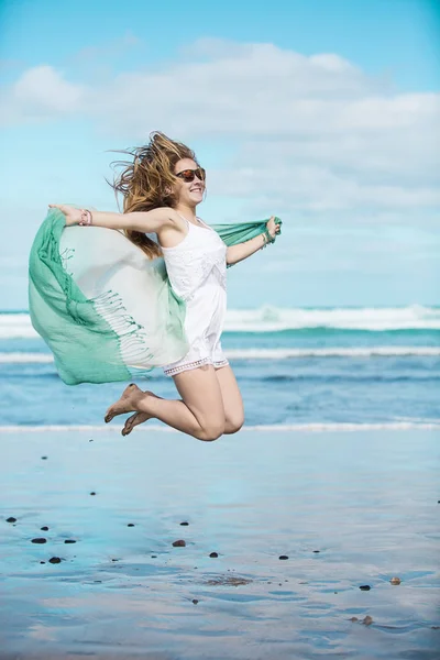 Happy female jumping on a beach Stock Photo