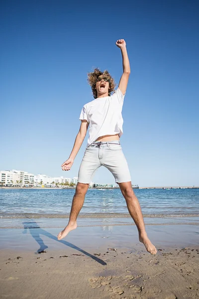 Homem pulando com a mão para cima — Fotografia de Stock