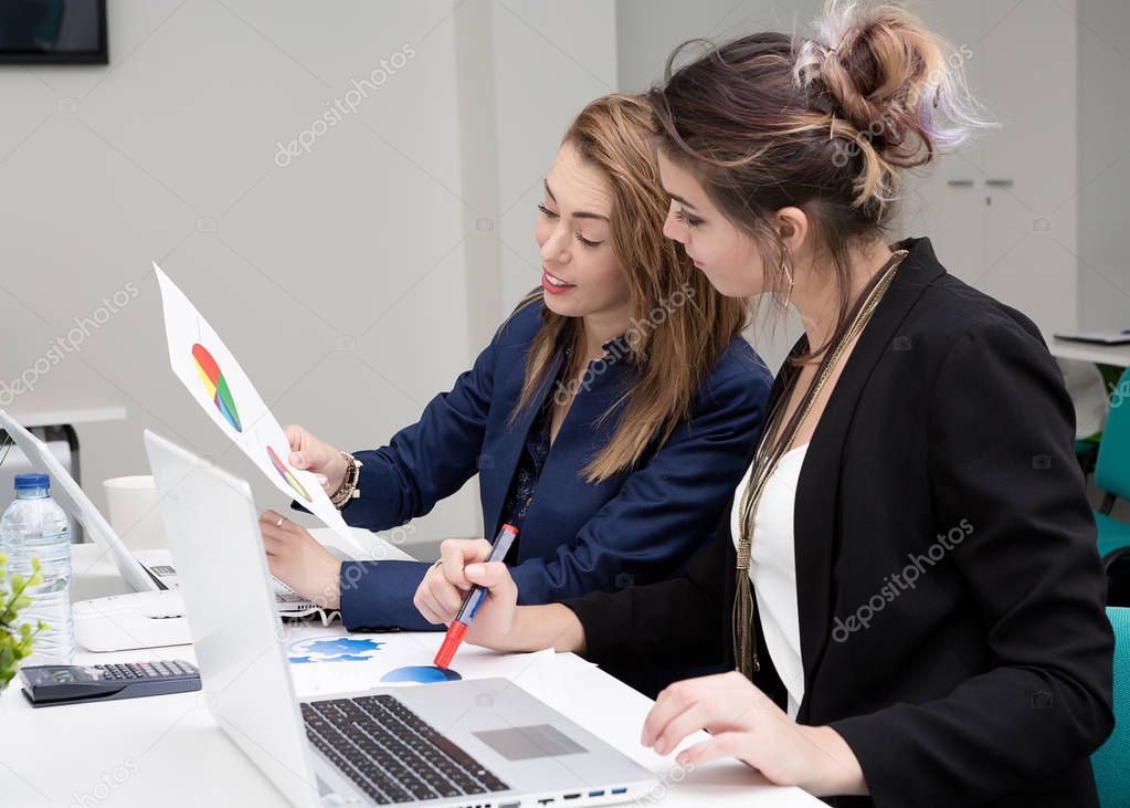 Women looking at diagrams in office