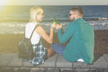 Deniz kenarında bira sahip çift