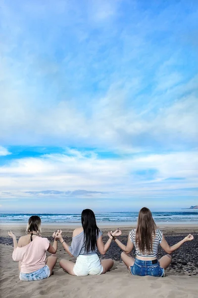 Jovens mulheres meditando na praia juntas — Fotografia de Stock