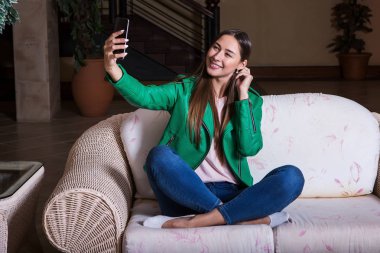 Oturan genç kadın kendini bir selfie yapma