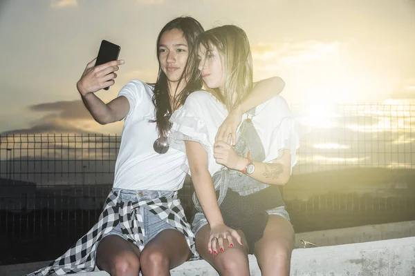 Contenu filles prendre selfie au coucher du soleil — Photo