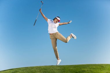 Neşeli kadın golf sahasında atlama