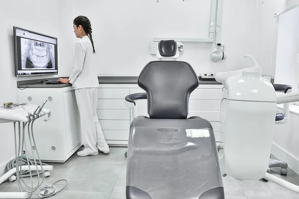 Lekarka Białym Mundurze Stojąca Obok Gabinetu Badająca Zęby Monitorze Komputerowym — Zdjęcie stockowe