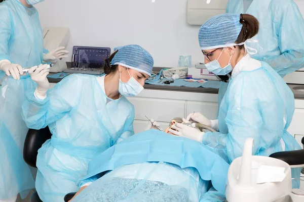 Kobieta Lekarz Biorąc Narzędzie Asystenta Upraw Podczas Leczenia Zębów Klienta — Zdjęcie stockowe