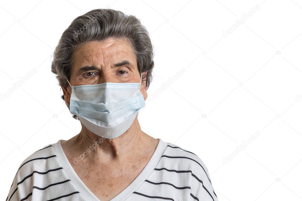 Elderly casual female with short hair protecting with medical mask during pandemic of coronavirus looking at camera