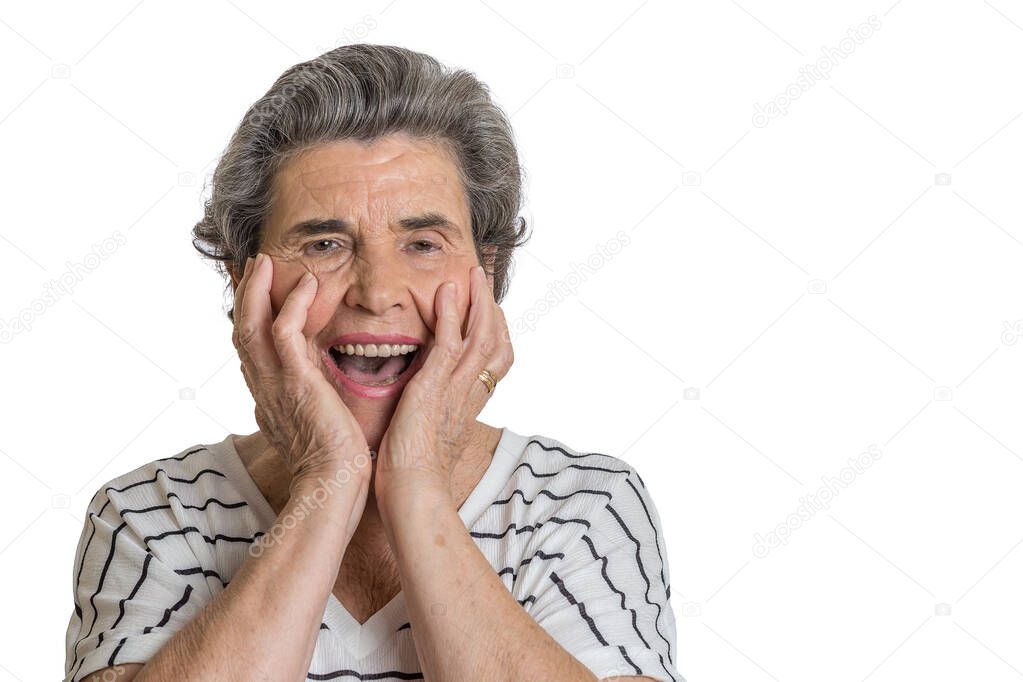 Surprised elderly woman with hands on cheeks looking at camera and screaming in amazement against white background