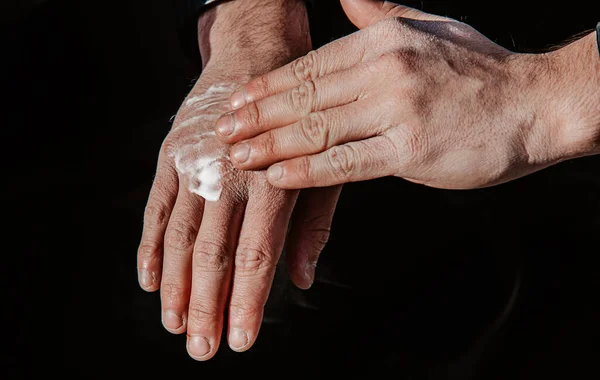 man creams his rough hands after using disinfectant lotion