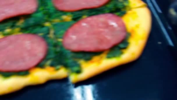 Pizza met spinazie wordt op tafel gelegd. Close-up. — Stockvideo