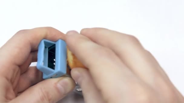 Le mani di uomini fregano una scorza arancione mini su una grattugia mini — Video Stock