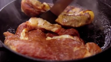 Tavada bir parça et pişirmek için, adam tavaya çiğ ve kırmızı bir parça domuz eti koydu, dökme demir tava.