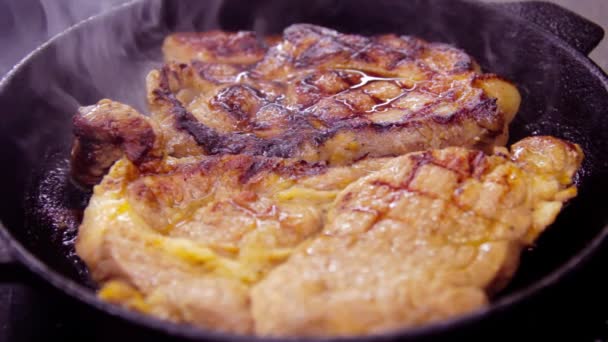 Om een stuk vlees in een pan te koken, deed de man in de pan een rauw en rood stuk varkensvlees, een gietijzeren koekenpan — Stockvideo