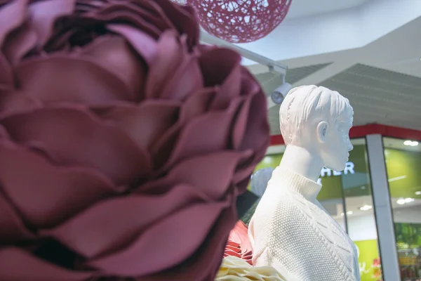 Moda roupas femininas no manequim na cabine de flores decorativas — Fotografia de Stock