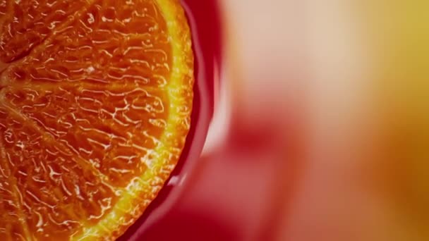 Slice of orange rotating close-up on red background — Stock Video