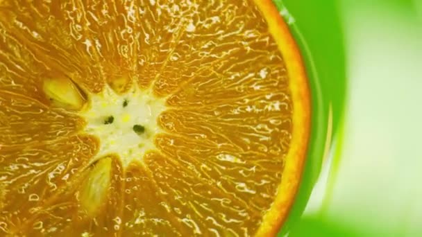 Rotating orange with green background. Beautiful light in the water — Stock Video