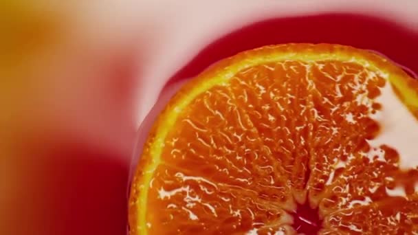 Slice of orange rotating close-up on red background — Stock Video