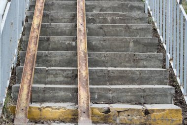 Tekerlekli sandalye rampası olan dış merdiven. Şehirdeki eski merdivenler.