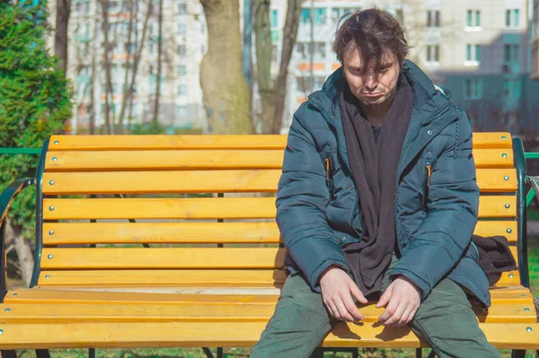 Depressive guy sitting on park benches.