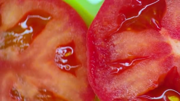 Närbild. Tomatskivor roterar på en grön bakgrund. ovanifrån — Stockvideo