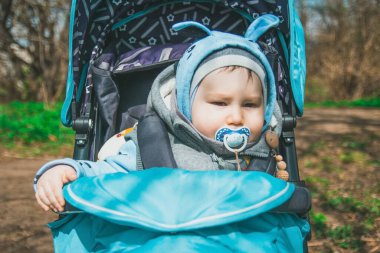 Moskova, Rusya, 4 Mayıs 2020: Çocuk baharda bir bebek arabasında ormanda