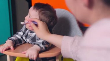 Mutlu çocuk. Anne oğlunu kaşıkla besliyor.