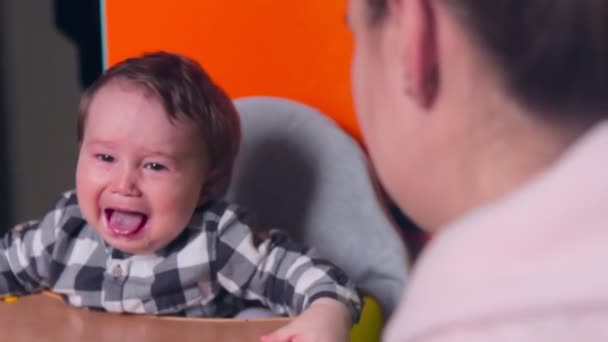 A mãe alimenta o bebé com uma colher. menino chorando — Vídeo de Stock