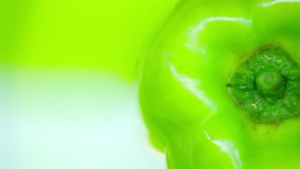 Grüne Paprika auf rotierendem grünem Hintergrund. Kopierraum. Ansicht von oben. Nahaufnahme. — Stockvideo