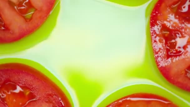 Närbild. Tomatskivor roterar på en grön bakgrund. Uppfattat utrymme. ovanifrån. — Stockvideo