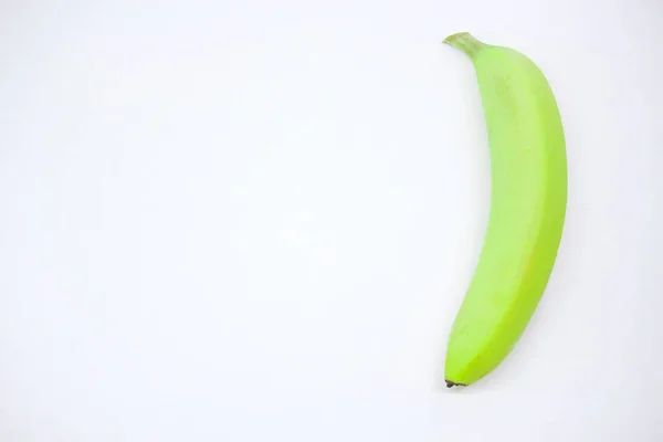 Single green banana against white background copy space — Stock Photo, Image