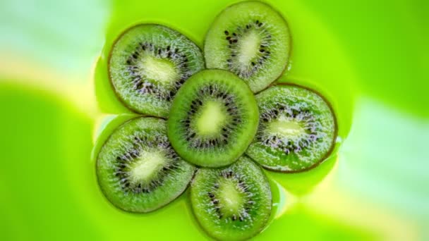 Slices kiwi rotates on a green background. top view. Closeup. — Stock Video