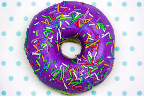 Donut roxo close-up em um espaço de cópia de fundo branco e turquesa — Fotografia de Stock